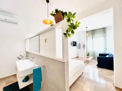 a white apartment with a sink and a living room at Villa di Nera Apartments in Palermo