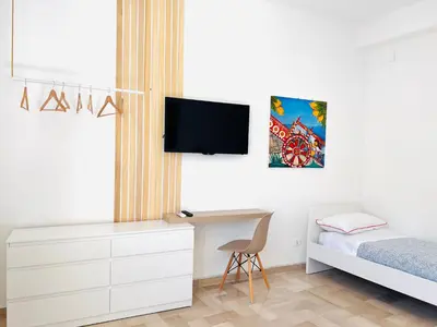 a bedroom with a bed and a desk with a tv at Villa di Nera Apartments in Palermo