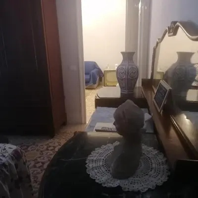 a room with a vase on a table and a mirror at Battisti 18 Vintage Rooms in Palermo