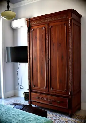 a wooden cabinet in a room with a tv at Battisti 18 Vintage Rooms in Palermo