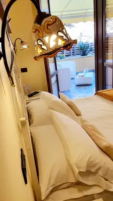 a bedroom with a bed with a lamp on it at Hotel Cala Marina in Castellammare del Golfo
