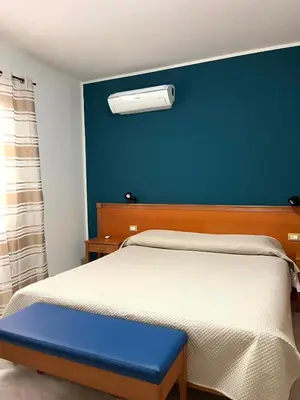 a bedroom with a bed with a blue wall at Hotel d'Orleans in Palermo