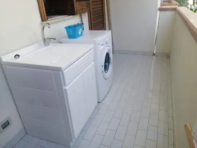 a white washer and dryer in a bathroom at Appartamento Corallo in San Vito lo Capo