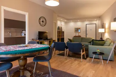 a living room with a couch and a table and chairs at La Paperella Blu Apartment in Termini Imerese