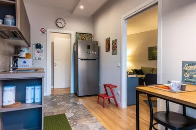 a kitchen with a refrigerator and a table in a room at La Paperella Blu Apartment in Termini Imerese