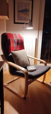 a chair with a blanket and a lamp in a room at La Paperella Blu Apartment in Termini Imerese