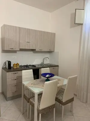 a kitchen with a table and chairs and a counter at Casa Katrin & Casa Brigida in Castellammare del Golfo