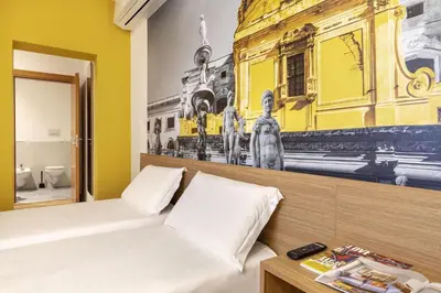 a bedroom with a bed and a painting on the wall at B&B Hotel Palermo Quattro Canti in Palermo