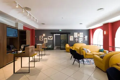 a waiting area with yellow chairs and a waiting room at B&B Hotel Palermo Quattro Canti in Palermo