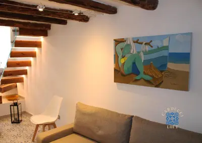 a living room with a couch and a painting on the wall at Carducci Loft in Castellammare del Golfo