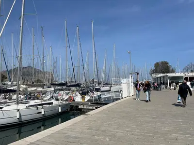 a group of people walking along a dock with boats at Relais del sole in Partinico