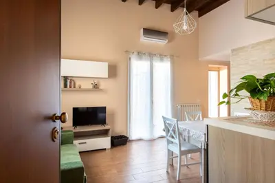 a kitchen and living room with a table and a television at Kalsa Apartment with Terrace by Wonderful Italy in Palermo