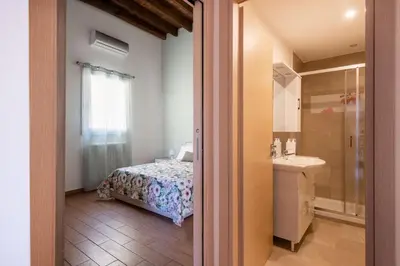 a bedroom with a bed and a bathroom with a sink at Kalsa Apartment with Terrace by Wonderful Italy in Palermo