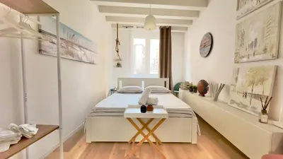 a white bedroom with a bed and a desk at Merlo Holiday Room in Palermo