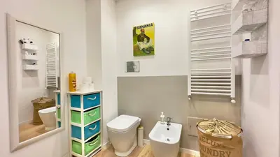 a white bathroom with a toilet and a sink at Merlo Holiday Room in Palermo