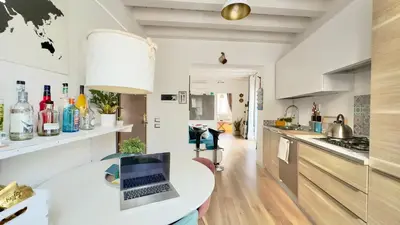 a kitchen with a table with a laptop on it at Merlo Holiday Room in Palermo