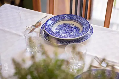 a blue and white plate and glasses on a table at CIATU ME' Scirocco in Castellammare del Golfo