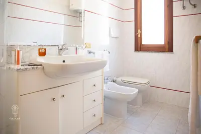 a white bathroom with a sink and a toilet at CIATU ME' Scirocco in Castellammare del Golfo