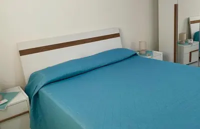 a bedroom with a bed with a blue blanket at AMATI HOLIDAYS in Palermo