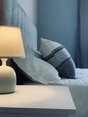 a bed with pillows and a table with a lamp at B&B Ungheria Ottantaquattro in Palermo