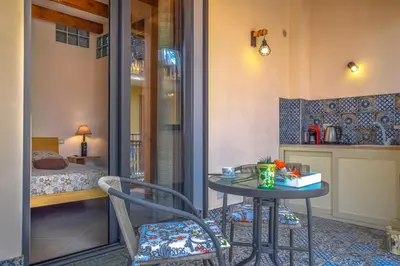 a small table and chair in a room with a bed at AMUNI' Apartments in Trabia