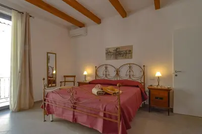 a bedroom with a bed with a dog laying on it at AMUNI' Apartments in Trabia