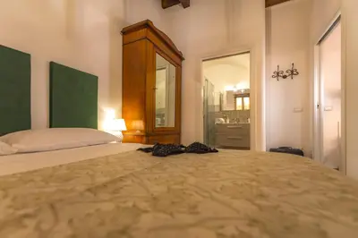 a bedroom with a large bed and a mirror at AMUNI' Apartments in Trabia