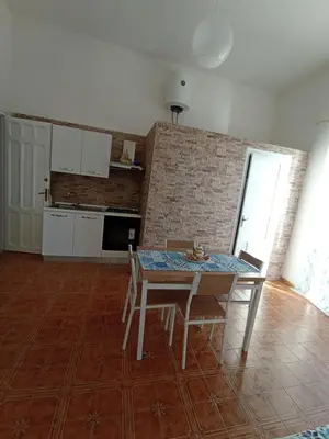 a kitchen with a table and chairs in a room at Casa bluchic Gioisia in Isola delle Femmine