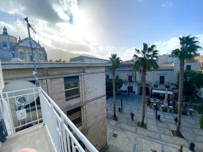 a view of a city with palm trees and a building at Casavacanze Alba in Alcamo