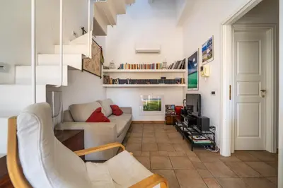 a living room with a couch and a staircase at Attico nel cuore del centro storico di Palermo in Palermo
