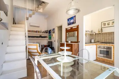 a kitchen and dining room with a glass table and chairs at Attico nel cuore del centro storico di Palermo in Palermo