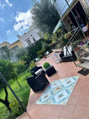 a patio with chairs and a rug in a yard at Belvedere in Palermo
