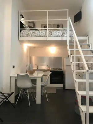 a white kitchen with a desk and a loft bed at EDU' in Alcamo
