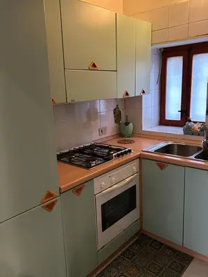 a kitchen with white cabinets and a stove top oven at toty alla guilla in Palermo