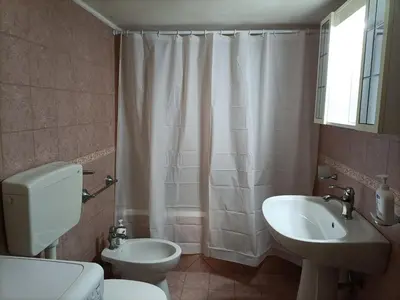 a bathroom with a white toilet and a sink at Casa di Lia in Montelepre