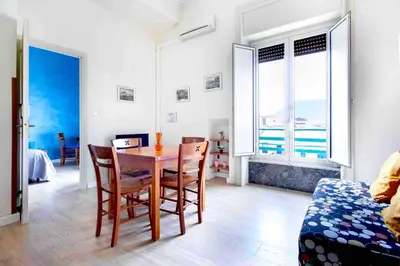 a dining room with a table and chairs with a view of the ocean at Casa Cavour in Palermo