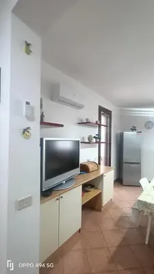 a living room with a television and a refrigerator at Casa Vita in centro in Balestrate