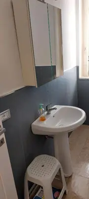 a bathroom with a sink and a mirror and a stool at Silvia's House in Palermo
