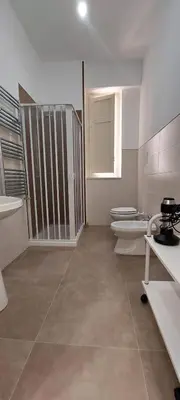 a white bathroom with two toilets and a window at Silvia's House in Palermo