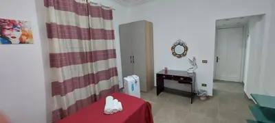 a living room with a red table and a mirror at Silvia's House in Palermo
