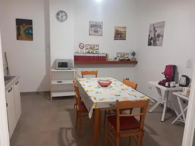 a kitchen with a table and chairs and a table and a microwave at Silvia's House in Palermo