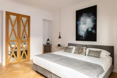 a bedroom with a large bed and a wooden door at Hotel Principe Di Villafranca in Palermo