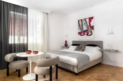 a bedroom with a bed and a table and chairs at Hotel Principe Di Villafranca in Palermo