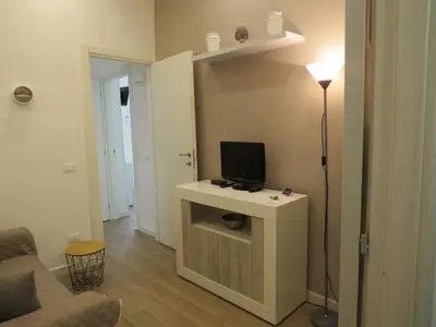 a living room with a tv on a table with a lamp at TRISOLE Palermo in Palermo