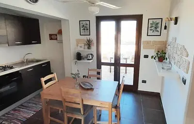 a kitchen with a table and chairs in a room at [TERRACE WITH VIEW] Attic in old town BallarHome in Palermo