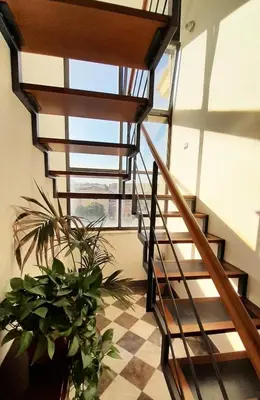 a spiral staircase in a building with potted plants at [TERRACE WITH VIEW] Attic in old town BallarHome in Palermo
