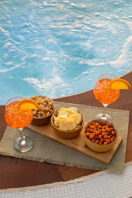 a table with bowls of food and two glasses of wine at Villa vista mare con piscina riscaldata a Trappeto in Balestrate