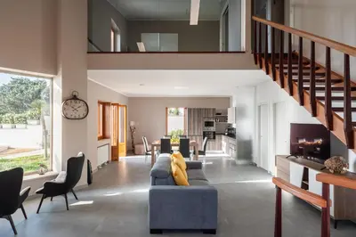a living room with a blue couch and a staircase at Villa vista mare con piscina riscaldata a Trappeto in Balestrate