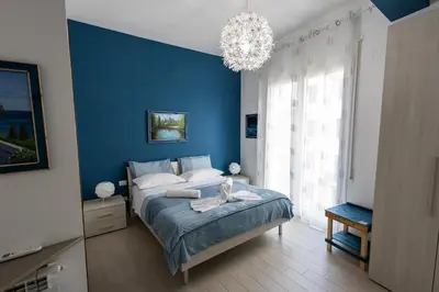 a blue bedroom with a bed and a chandelier at PalerMonAmour Art Gallery Suite in Palermo
