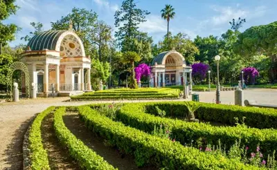 a park with a building and a garden with bushes at casadifederica in Palermo